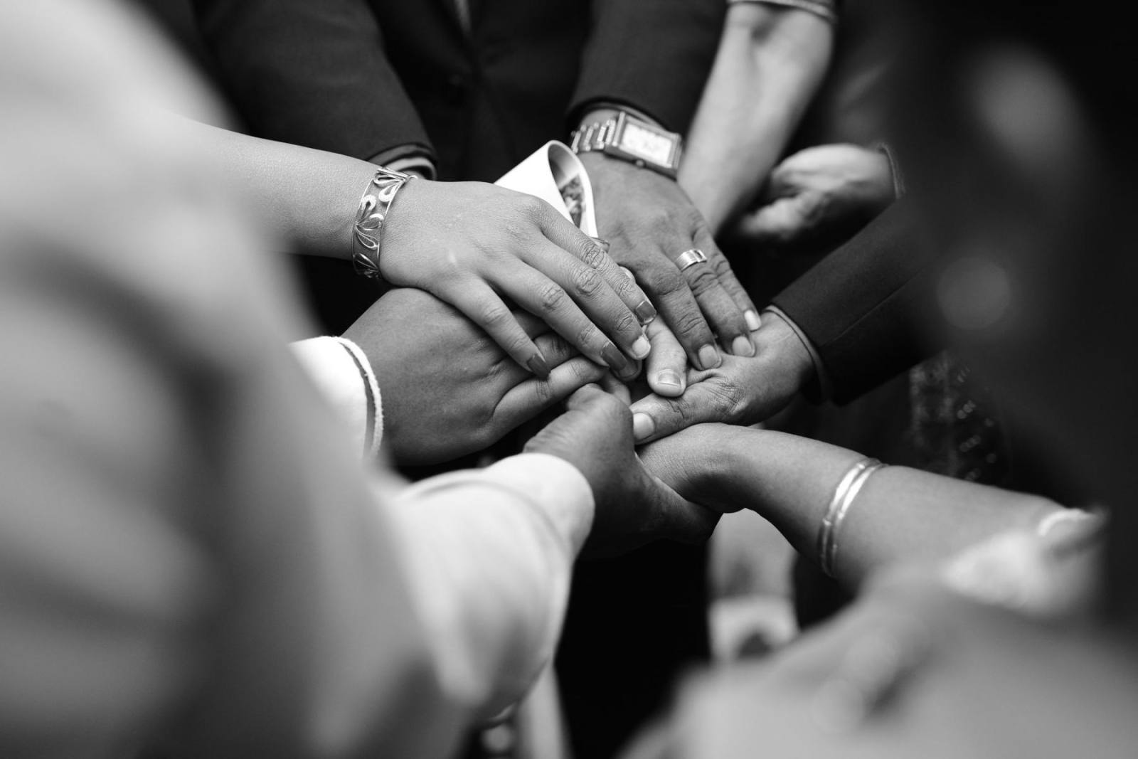 Hands stacked together in the middle of a group